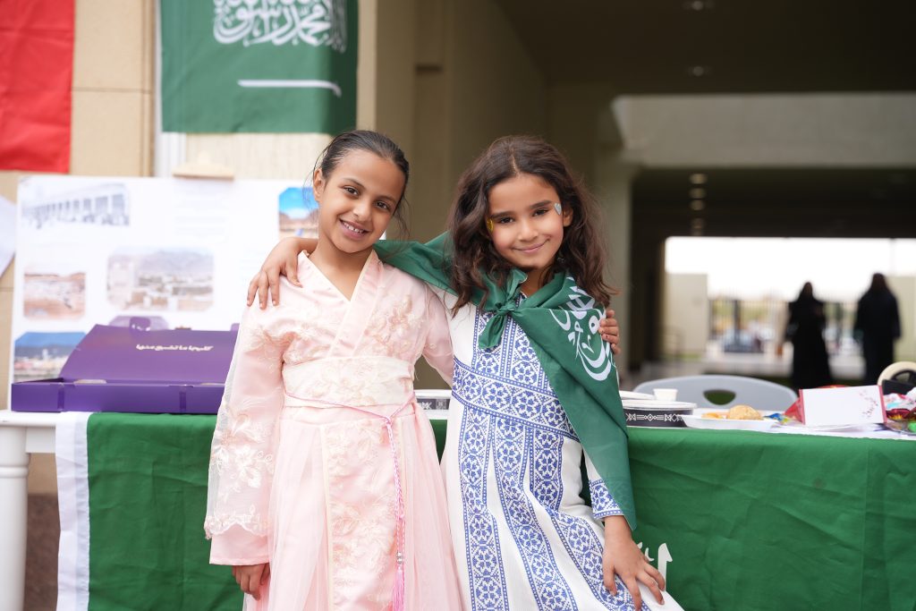 Two pupils in traditional Saudi dress at a school cultural celebration