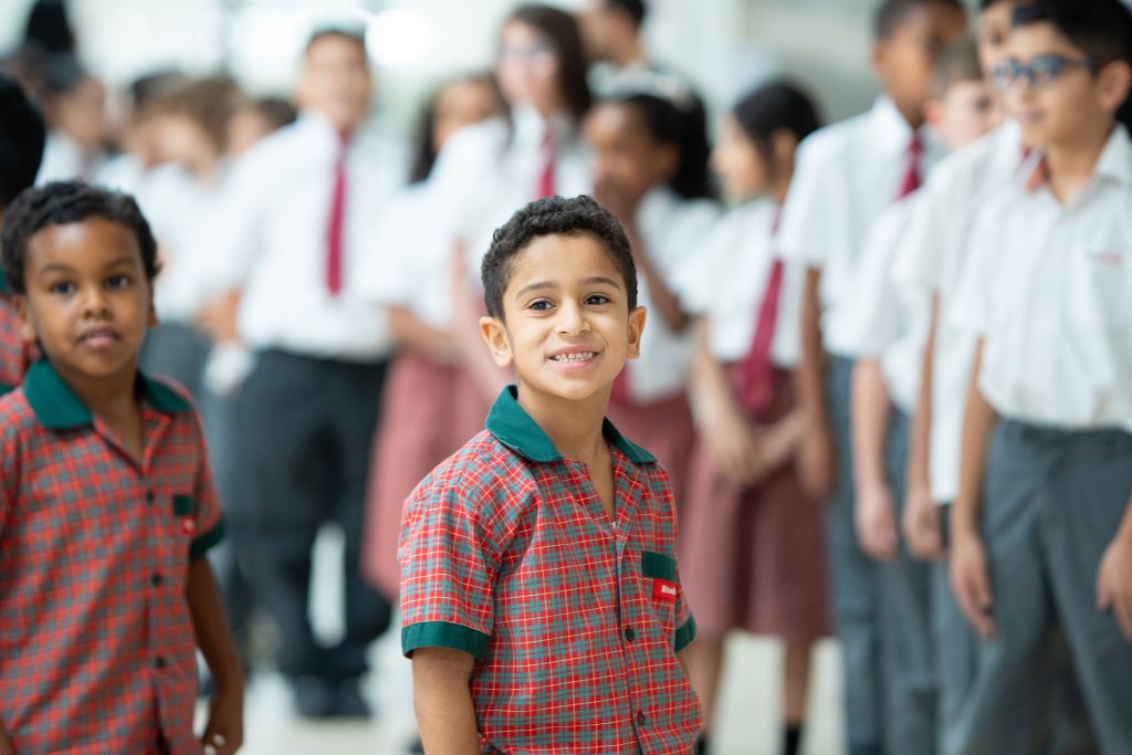 Smiling pupil lining up with classmates at EtonHouse Riyadh