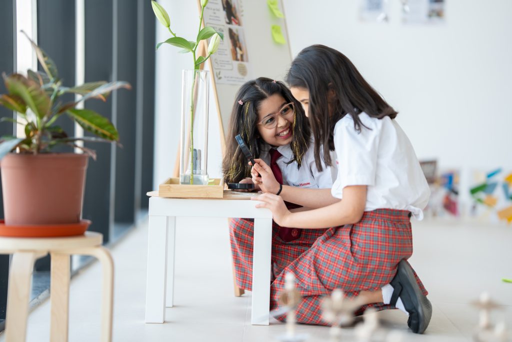 Two pupils sharing a warm moment in a calm classroom corner