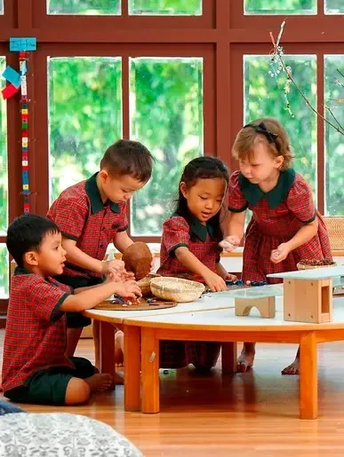 Preschool children exploring natural materials together at a low table